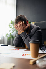 Stressed businessman suffering headache and burnout at office desk