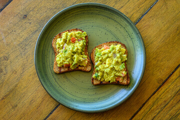 Guacamole Avocado Toast with Fresh Vegetables on Whole Grain Bread