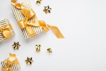 Merry Christmas and Happy Holidays greeting card, frame, banner. New Year. Golden Christmas decoration and gifts, presents on white background top view. Xmas holiday festive theme.	
