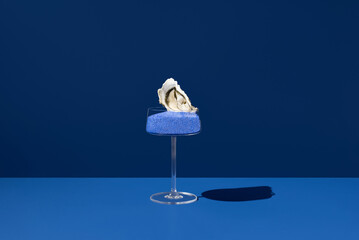 Oyster with blue salt and lemon in cocktail glass