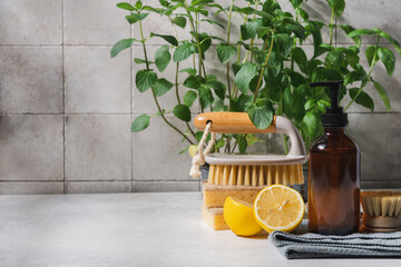 Eco friendly cleaning concept with glass bottle detergent, natural brushes and sponges on...