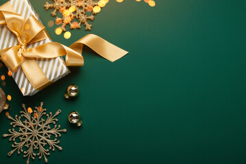 Merry Christmas and Happy Holidays greeting card, frame, banner. New Year. Golden Christmas decoration and gifts, presents on green background top view. Xmas holiday festive theme.