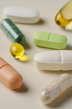 Variety of colorful pills and supplements on beige background