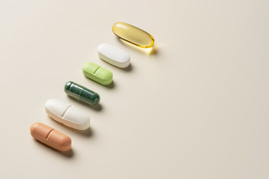 Assorted pills on light beige surface