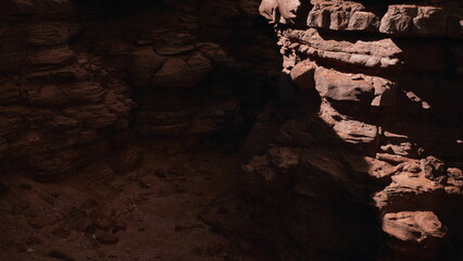 Shadows dance across rugged rock formations as dusk settles in a deep canyon. The warm hues of the earth contrast beautifully with the darkening sky, creating an enchanting atmosphere.