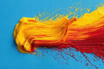 Vibrant abstract featuring a smear of yellow, orange, and red paint against a blue backdrop