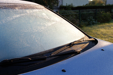 frost on car window and bright dazzle morning sunlight