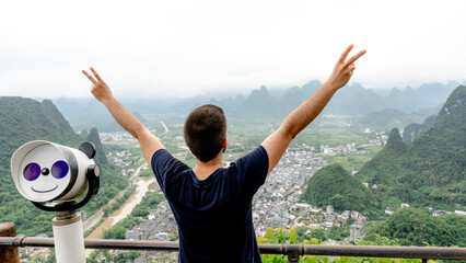 Man celebrating view from Laozhai Hill in Xingping