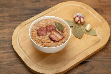 Baked beans with sausage and bacon, garlic and bay leaf