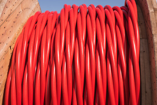 Red electrical cables on large wooden spool
