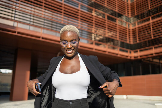 Confident businesswoman smiling in modern cityscape