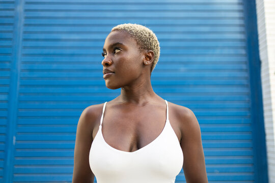 Confident businesswoman standing against blue background
