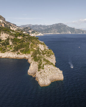 Aerial view of rocky cliffs plunging into the deep blue sea, with the town nestled above, a captivating contrast of nature and architecture, Conca dei Marini, Amalfi Coast, Campania, Italy.