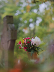 Leuchtende Blumen in Vase am Grab