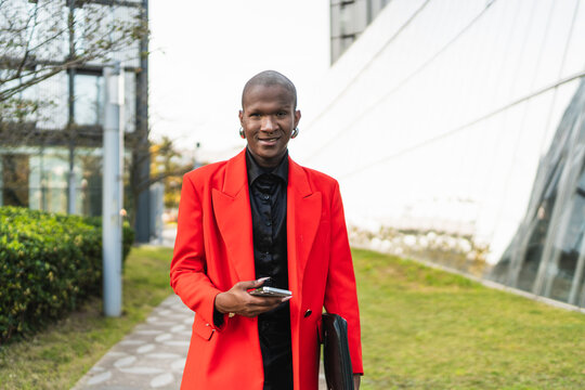 Young lgbtq man in vibrant red blazer outside office