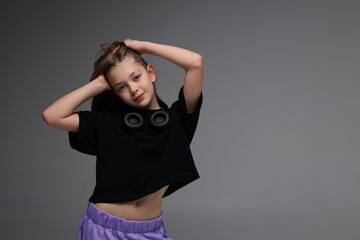 Young caucasian female child with headphones posing confidently in studio