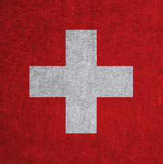 Obraz premium Flag of Switzerland on an ancient concrete surface. Concept of Swiss heritage and patriotism.