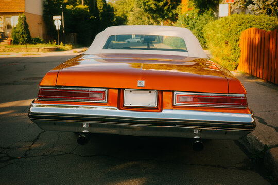 Classic orange convertible car on sunny street