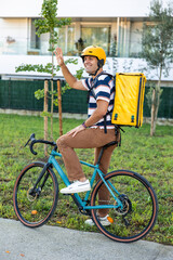 vertical Hispanic male delivery man waving while riding bike