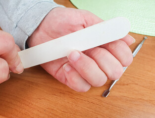 Nail file. A woman files and trims her fingernails. Manicure procedure, cosmetic care.