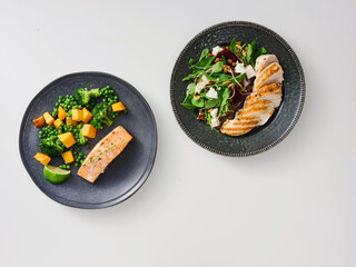 A well-balanced meal features grilled salmon fillet next to sautéed broccoli and diced mango, accompanied by a fresh salad on a dark plate, perfect for a nutritious dinner