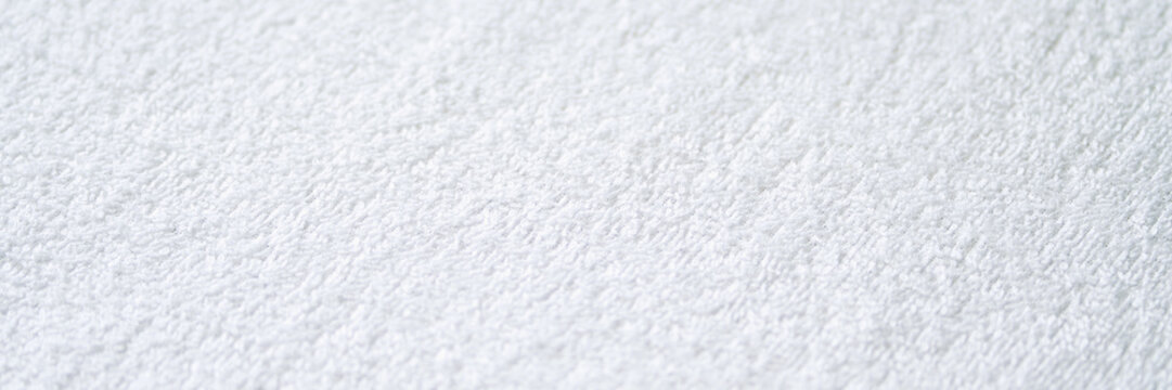 Close-up of white textured terry cloth fabric with soft and absorbent material surface.