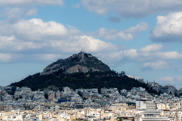 Photo of the Lycabettus hill in Athens city , Blue sky with clouds at the background.