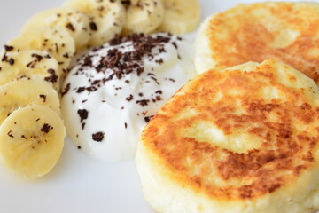 Golden Cottage Cheese Pancakes with Banana, Cream and Chocolate Shavings