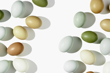 Top view natural easter Eggs with shadows on light background, minimal trend food pattern from assorted organic Chicken egg with neutral earth color eggshells, Easter food celebration