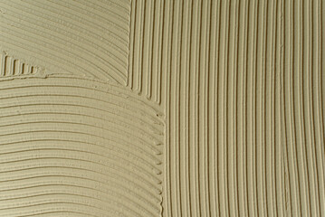 Beige textured background with abstract curved pattern of plaster or putty