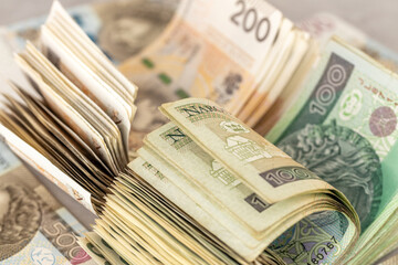 Poland money. A large stack of 100 and 200 zloty bills. Polish finances. Business background, economic concept. Polish savings, analysis of expenses, investments, housing loans, stock market.
