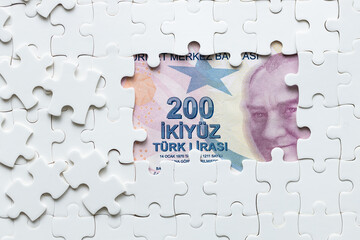  Turkish lira among scattered puzzle pieces. Economic and Financial concept.