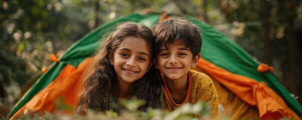 Happy children smiling near a colorful tent in an outdoor forest setting