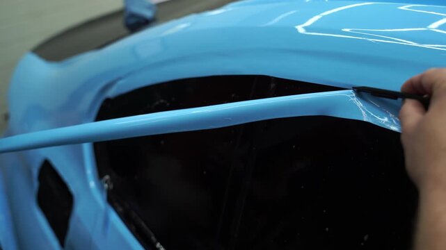 4k video applying a high-gloss blue PPF using a green squeegee ensures a bubble-free. Blue PPF applied with green squeegee during detailing car to preserve finish and block damage.