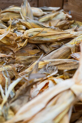Dried corn husks piled together in a rustic wooden container during the harvest season
