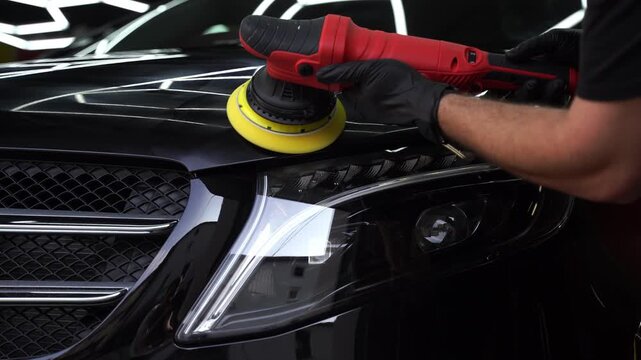 Car hood being polished with yellow pad 4k video. Paint polishing in active motion. Paint polishing to eliminate swirl marks and restore deep gloss. Detailing car for sealant or ceramic application.