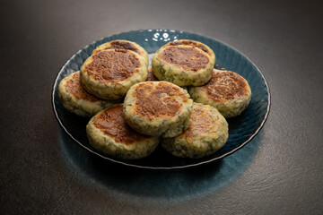 Cottage cheese pancakes or fritters with herbs, green onions, and parsley. Pan-fried syrniki with dill. A healthy breakfast or a dietary lunch. Copy space.