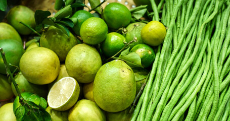 Lemon Lime and yardlong beans in woven basket selling on the street market.