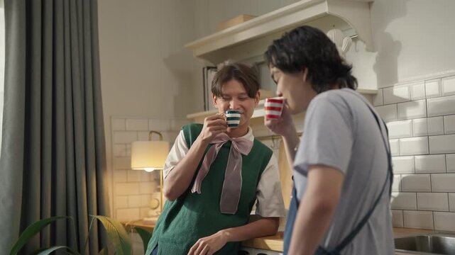 Asian mature man enjoys morning coffee at cafe using drip coffee bag in beige cup on white wood table, while young adult friends relax making specialty coffee as hobby activity at home