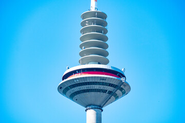 German high Europaturm TV and radio broadcasting tower against blue sky, city’s modernity,...