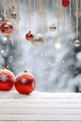 Red and silver Christmas balls on white wooden board surfave covered with snow and snowfall on abstract background in winter.