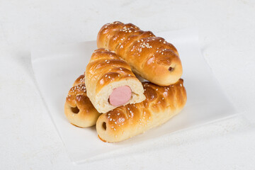 Sausages in the dough. Fast food. On paper. White background. Close up
