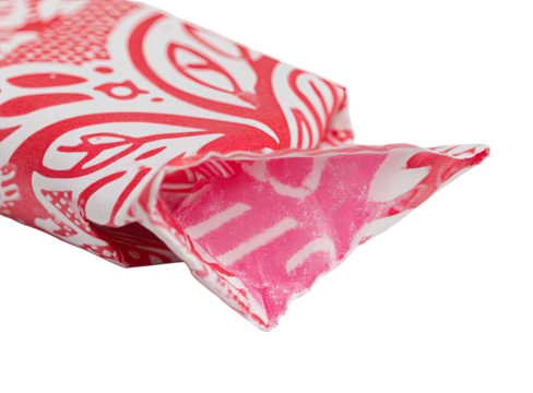 Close-up of a candy wrapper. Red and white patterned wrapper,  pink candy visible