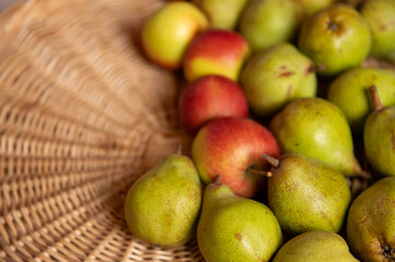 Ripe juicy pears on a wicker background. Rustic fruit composition, perfect for themes of health, diet, organic food, and natural lifestyle.