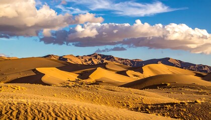 A serene desert landscape bathed in golden sunlight, with rolling sand dunes leading towards distant mountains under a cloudy sky