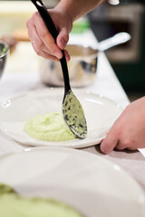 Chef plating creamy celeriac puree on plate
