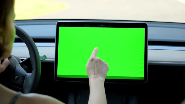 Close up view of the woman browsing on control monitor screen with chroma key screen inside  car