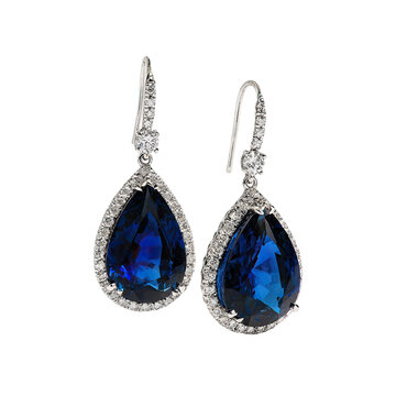 Pair of pear-shaped, drop earrings featuring a deep blue gemstone, likely sapphire or a comparable synthetic, nestled within a halo of smaller stones, likely diamonds or a similar material.  