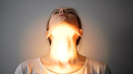 Peaceful young woman meditating with glowing light at throat symbolizing inner energy and balance