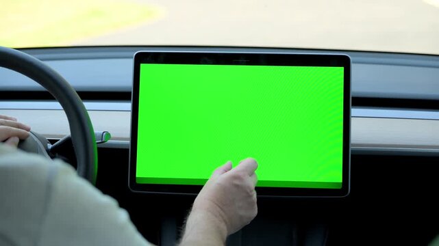 Close up view of man browsing on control monitor screen with the chroma key screen inside car